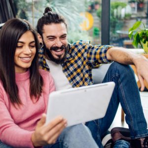 Young couple relaxing at home and using digital tablet. Young couple relaxing at home and using digital tablet.