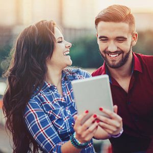 Smiling young couple with digital tablet outdoors in the city Smiling young couple with digital tablet outdoors in the city